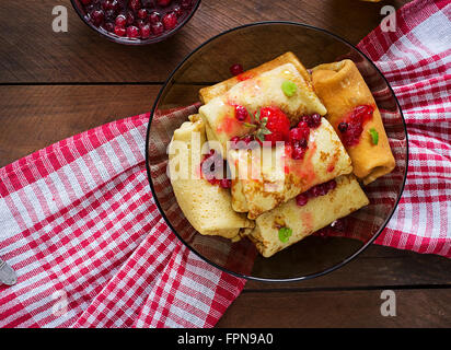 Golden frittelle con marmellata di mirtilli e miele in uno stile rustico. Vista superiore Foto Stock