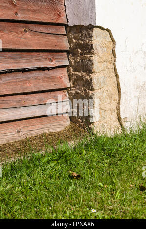 Danneggiato angolo della parete in calcestruzzo con peeling gesso Foto Stock