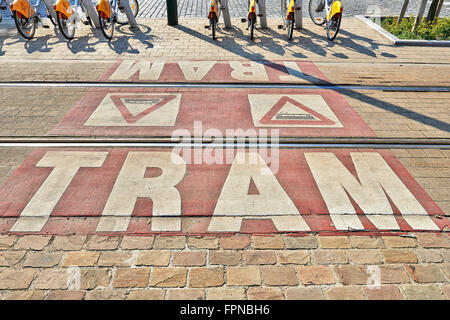 Cartelli di avvertimento sul terreno per la sicurezza dei pedoni dalla fermata di tram la priorità Foto Stock