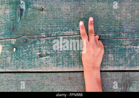 Una mano ci dice il giusto numero uno, due, tre, quattro, cinque su un vecchio tavolo in legno Foto Stock