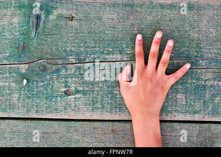 Una mano ci dice il giusto numero uno, due, tre, quattro, cinque su un vecchio tavolo in legno Foto Stock