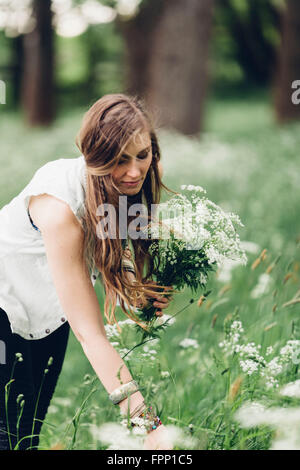 Giovane donna a caccia di fiori, Foto Stock