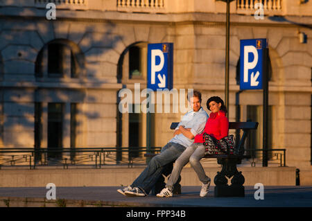 Poelaert square, il quartiere Marolles, Bruxelles, Belgio. Una coppia romantica seduta su una panchina in piazza accanto all'elevat Foto Stock