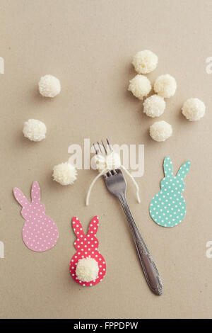 Pasqua artigianato del filato pom pom bunny coda con una forcella Foto Stock