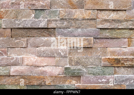 Dettaglio di un muro di pietra di grossolani, color pastello pietre affacciate Foto Stock