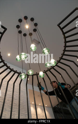 Workman mettendo i tocchi finali a un ferro ringhiera decorativa all'interno di un nuovo edificio di modifica in san Paolo Londra UK. Foto Stock