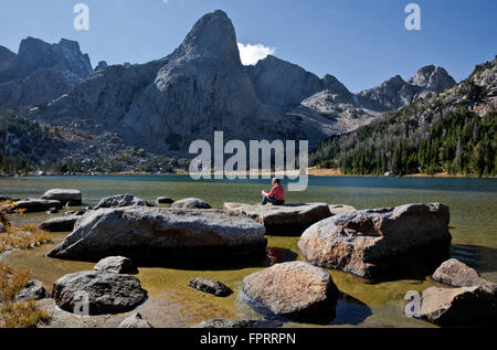 WY01342-00...WYOMING - escursionista relax sulle rive del lago Lonesome nel Cirque di torri area del Wind River Range. Foto Stock