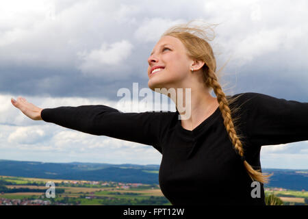 Giovane donna felice con le braccia tese Foto Stock