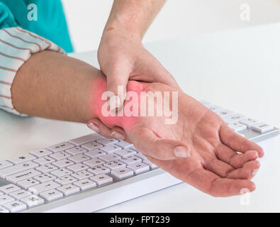 Lavoratore con il dolore al polso dal duro lavoro in ufficio Foto Stock