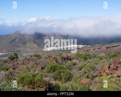 Santiago del Teide sotto una nuvola, vista da una escursione nelle montagne vulcaniche che circondano la valle, Tenerife Isole Canarie Foto Stock