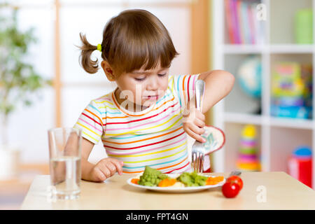 Kid ragazza mangiare sano verdure in asili nido o Foto Stock