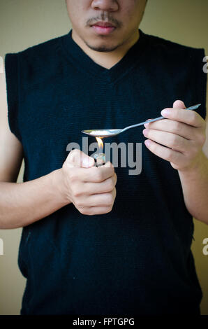 L uomo si prepara il farmaco in cucchiaio Foto Stock