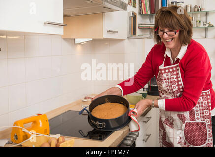 Donna senior di preparare la torta in cucina, Monaco di Baviera, Germania Foto Stock