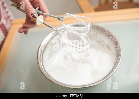 Senior donna holding frusta su meringa ciotola riempita, Monaco di Baviera, Germania Foto Stock