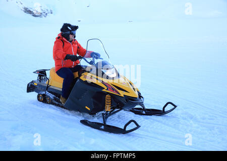 In sella ad una motoslitta attraverso la neve a Balea Lac, nelle montagne Faragas, in Transilvania, Romania, Est Europa Foto Stock