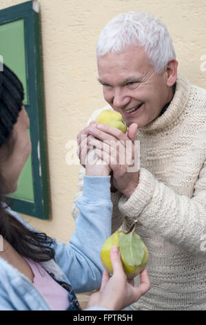 Negozio di femmina Assistant fornisce le mele cotogne al client per annusare, Baviera, Germania Foto Stock