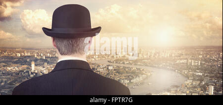 Imprenditore con cappello bowler guardando finanziario dello skyline della città concetto per finanziare gli investimenti, carriera e opportunità Foto Stock