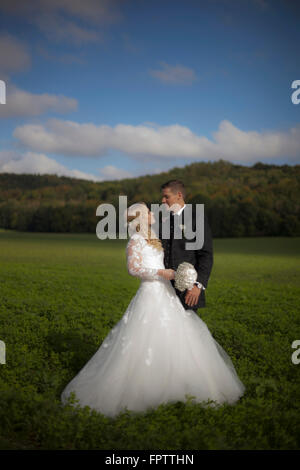 Sposa e lo sposo facendo romance in campo, Ammersee, Alta Baviera, Baviera, Germania Foto Stock