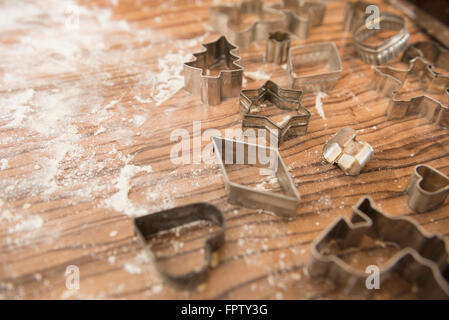 Diversi tipi di cookie cutter e sparse sulla farina di legno scuro di Monaco di Baviera, Germania Foto Stock