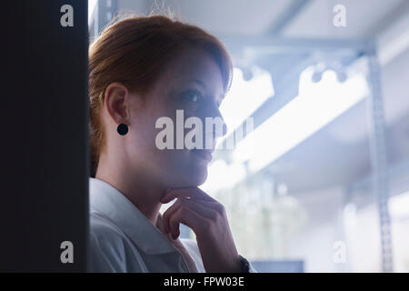 Close up di un giovane ingegnere femmina pensando in un impianto industriale di Freiburg im Breisgau, Baden-Württemberg, Germania Foto Stock