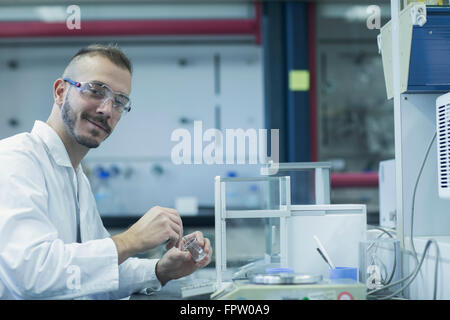 Ritratto di un giovane maschio scienziato che lavora in un laboratorio di farmacia, Freiburg im Breisgau, Baden-Württemberg, Germania Foto Stock