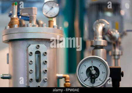 Immagine di apparecchiature industriali con la messa a fuoco su un manometro meccanico. Foto Stock