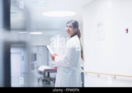 Giovani donne medico utilizzando una tavoletta digitale in ospedale corridoio, Freiburg im Breisgau, Baden-Württemberg, Germania Foto Stock