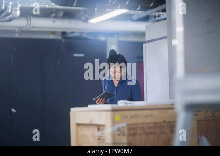 Giovane ingegnere femmina utilizzando digitale compressa in un impianto industriale di Freiburg im Breisgau, Baden-Württemberg, Germania Foto Stock