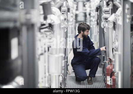 Giovane maschio ingegnere in un impianto industriale di Freiburg im Breisgau, Baden-Württemberg, Germania Foto Stock