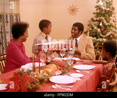 Anni Settanta famiglia americana africana a vacanze di Natale e Capodanno cena tabella padre madre figlio e figlia Foto Stock