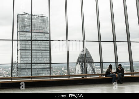 Giovane su sky garden giardino sul tetto di uno di londra iconico grattacieli, i walkie talkie rivolta verso il cetriolino e leadenham grattacieli. Foto Stock