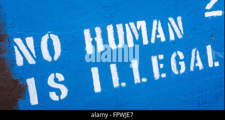 Nessun essere umano è illegale stampata graffiti nella parte occidentale di Belfast Foto Stock