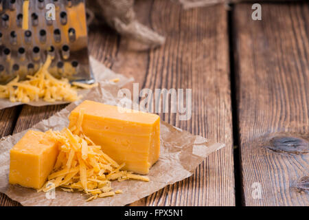 Formaggio Cheddar grattugiato su rustico sfondo di legno Foto Stock