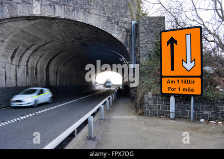 A55 North Wales coast road. Veicoli che passano attraverso la penna y tunnel Clip sulla carreggiata in direzione est. Cartello bilingue. Foto Stock