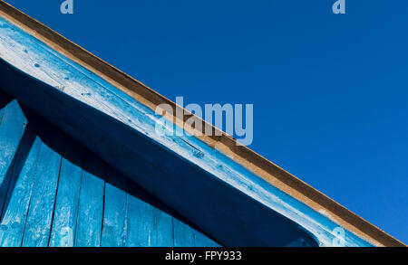 Vecchio sbiadito blu tetto in legno set astratta contro un cielo blu sullo sfondo. Copia area spazio per design e architettura idee a tema Foto Stock