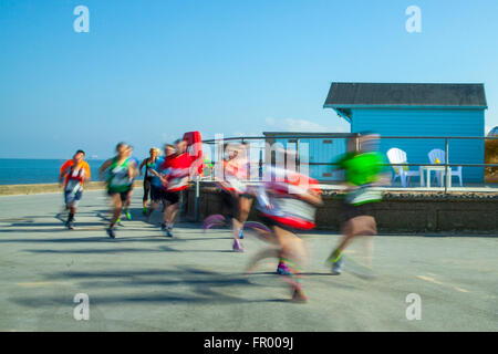 Fleetwood lungomare corsa; corridori sfocati in movimento sulla spianata costiera. Velocità di esecuzione di 10k Charity. I corridori si sono riuniti sul lungomare per una corsa di beneficenza organizzata dal Rotary Club di Fleetwood, Lancashire, Regno Unito Foto Stock