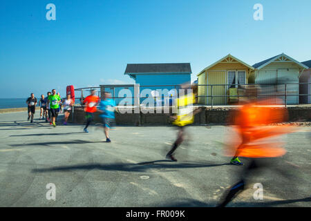 Fleetwood lungomare corsa; corridori sfocati in movimento sulla spianata costiera. Velocità di esecuzione di 10k Charity. I corridori si sono riuniti sul lungomare per una corsa di beneficenza organizzata dal Rotary Club di Fleetwood, Lancashire, Regno Unito Foto Stock