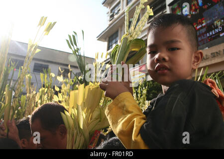 Marzo 20, 2016 - Filippine - un giovane ragazzo porta un palm frond in Quiapo, Manila. Cattolici devoti accorrevano Quiapo Chiesa a Manila come onda loro fronde di palma mentre benedetti da sacerdoti durante la Domenica delle Palme. (Credito Immagine: © J Gerard Seguia via ZUMA filo) Foto Stock