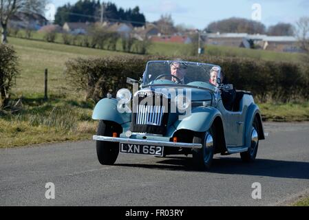 Eaglesham, East Renfrewshire, Scotland, Regno Unito. Xx marzo, 2016. Il bel tempo nella zona di Glasgow ha permesso a questo giovane il piacere di avere il tetto verso il basso sulla loro cantante Roadster 4AB classic car. Foto Stock