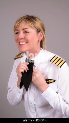 Senior compagnia femminile capitano clipping lei cravat uniforme sulla sua maglietta Foto Stock