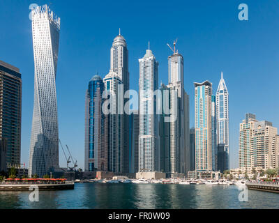 Barche e highrise waterfront edifici nel quartiere di Marina di Dubai, Emirati Arabi Uniti Foto Stock