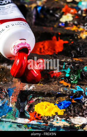 La vernice rossa schiacciata su una tavolozza degli artisti. Foto Stock