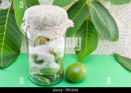 Giovani noci con lo zucchero in una giara Foto Stock