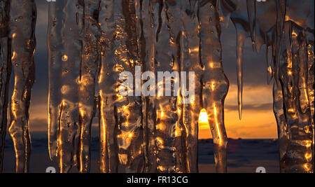 Regolazione del sole viene riflessa in ghiaccioli. Foto Stock