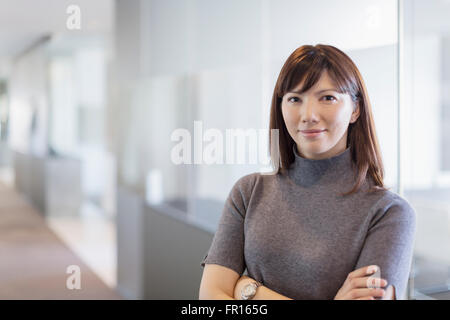 Ritratto fiducioso imprenditrice con le braccia incrociate Foto Stock