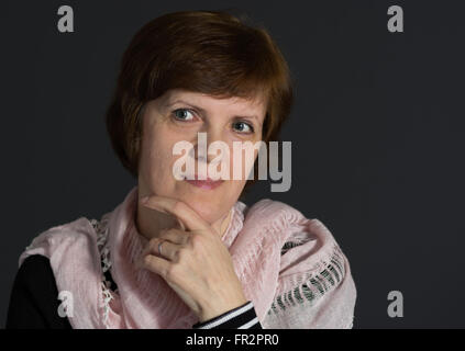 Ritratto di bella coppia Caucasian donna che indossa scialle sullo spallamento contro uno sfondo scuro Foto Stock