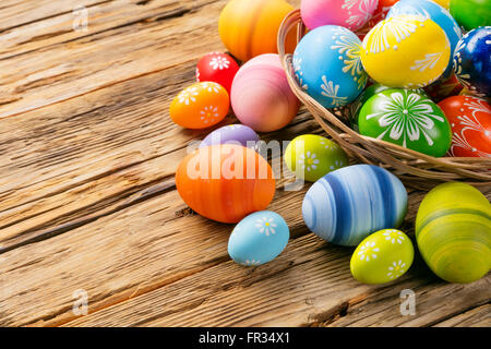 Decorazione di pasqua con uova colorate e tulipani su rustiche tavole Foto Stock