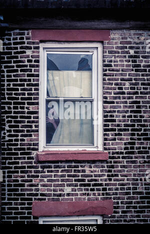 Faccia guardando fuori della finestra, New York City, Stati Uniti d'America. Foto Stock