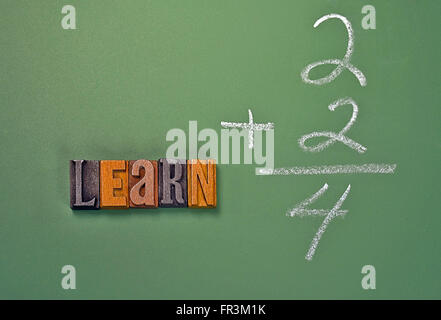 La parola a imparare in legno vintage tipo di stampa in rilievo con un semplice problema di matematica sulla lavagna verde. Foto Stock