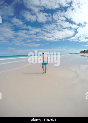 Persone: uomo a camminare sulla spiaggia con la sua testa in basso. Foto Stock